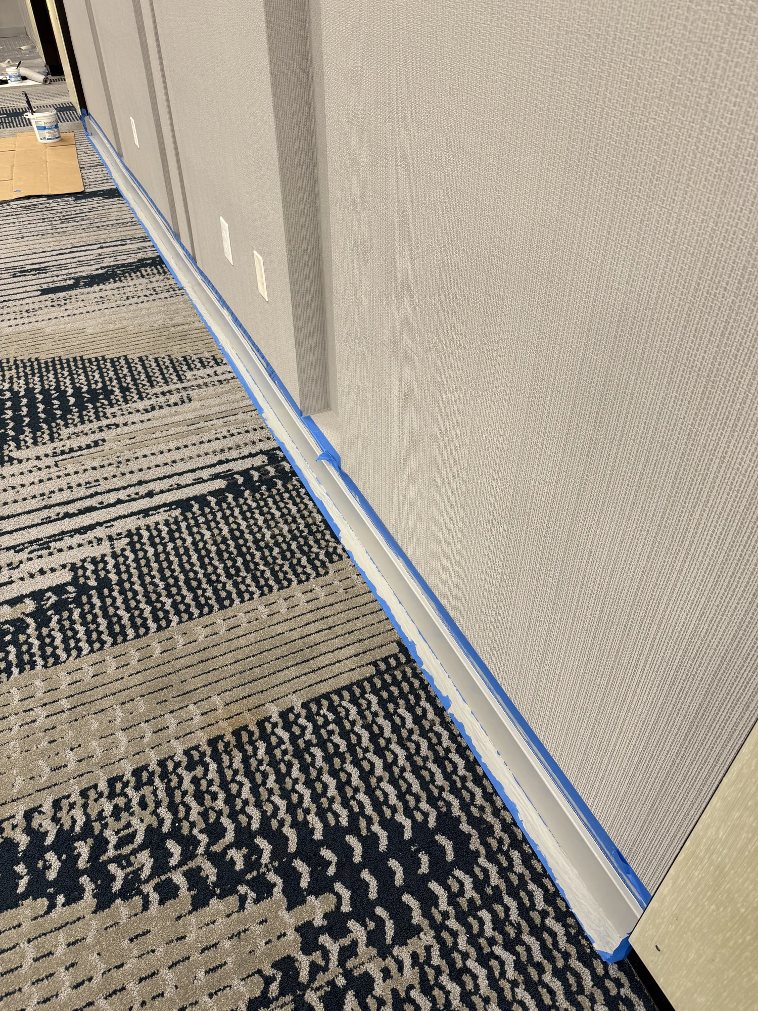 Wallcovering texture and base trim with protective tape still in place · Hotel Alba Tampa, Tapestry Collection by Hilton