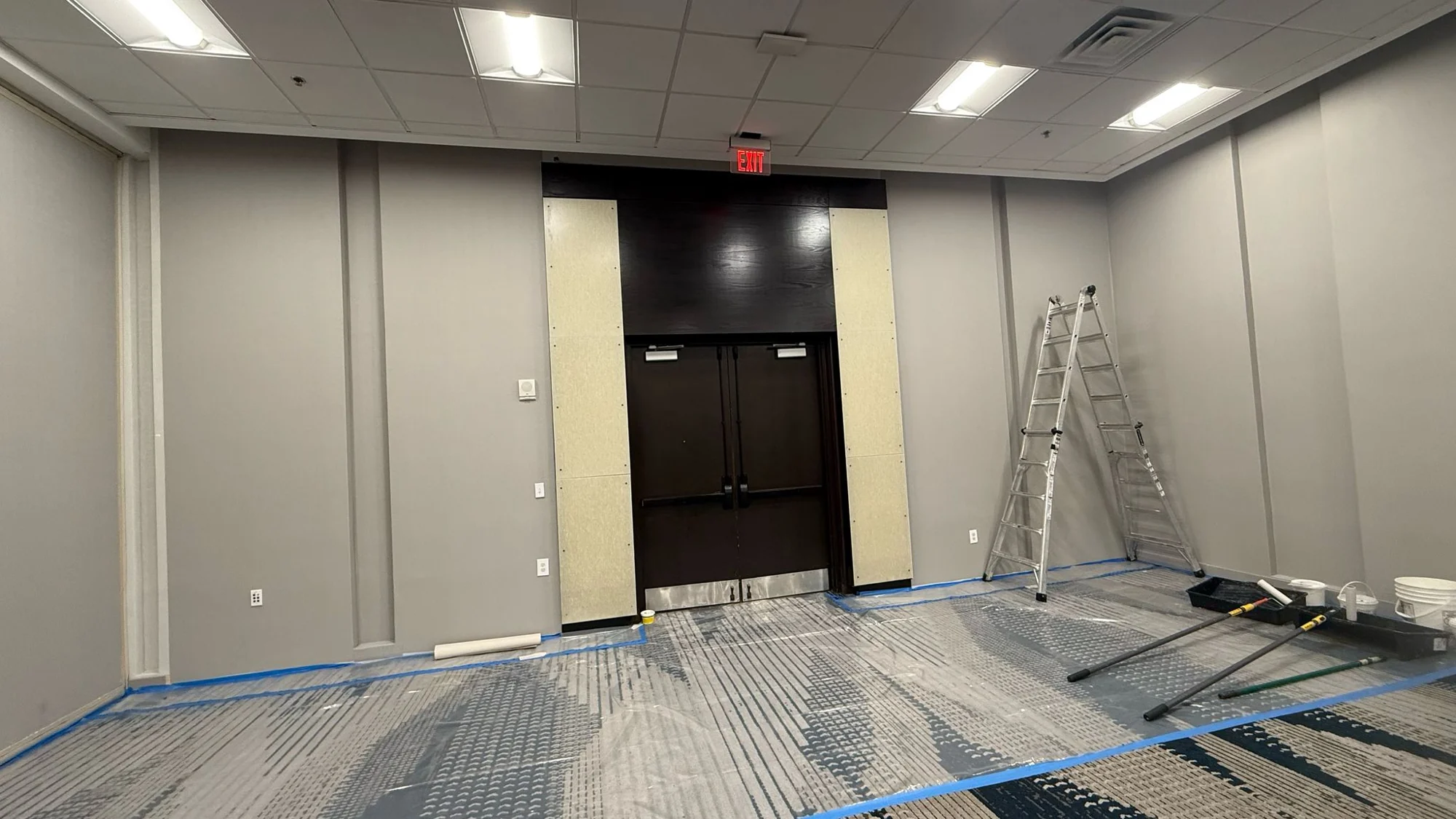 Wallcovering and doorway work in progress with protective tape and tools in place · Hotel Alba Tampa, Tapestry Collection by Hilton