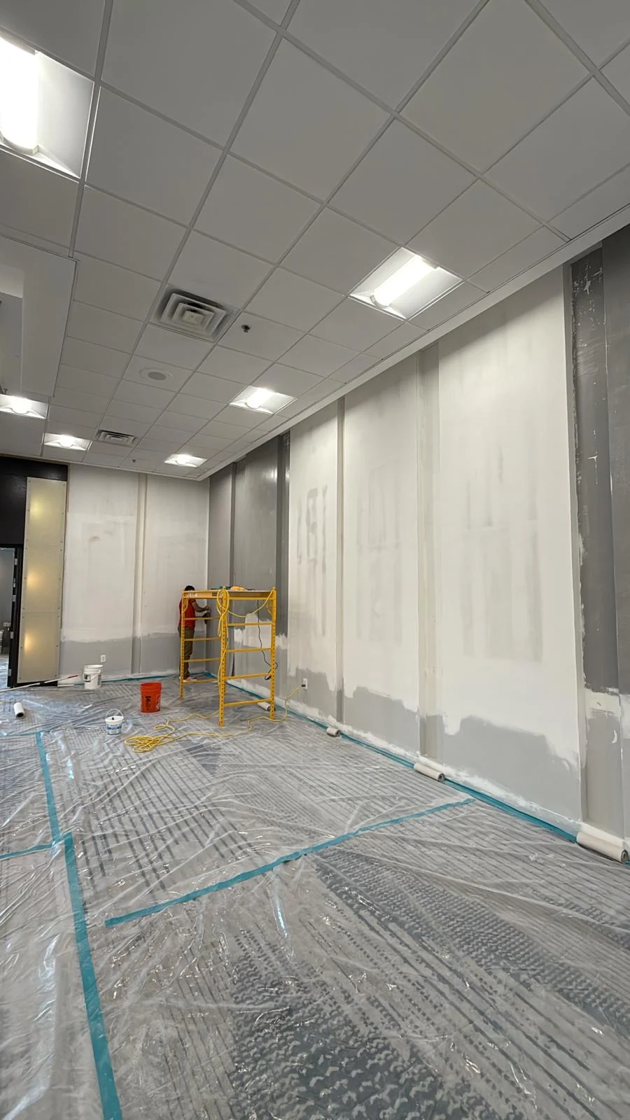 Ballroom wall preparation between vertical trim with scaffold and existing carpet protected · Hotel Alba Tampa, Tapestry Collection by Hilton