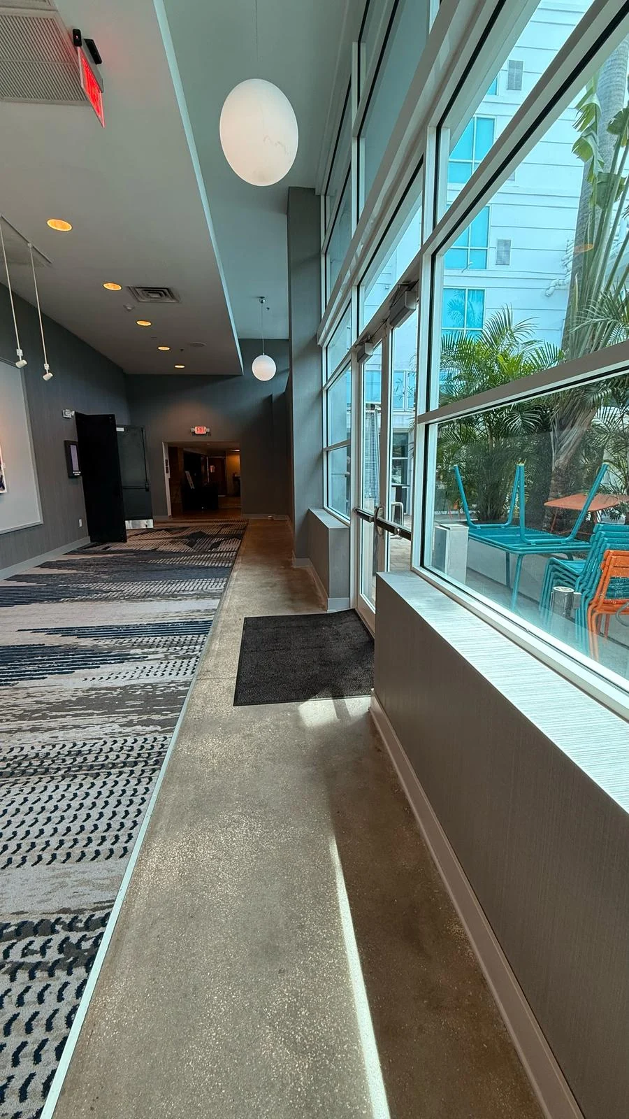 Installed wallcovering along the window-side passage toward the ballroom · Hotel Alba Tampa, Tapestry Collection by Hilton