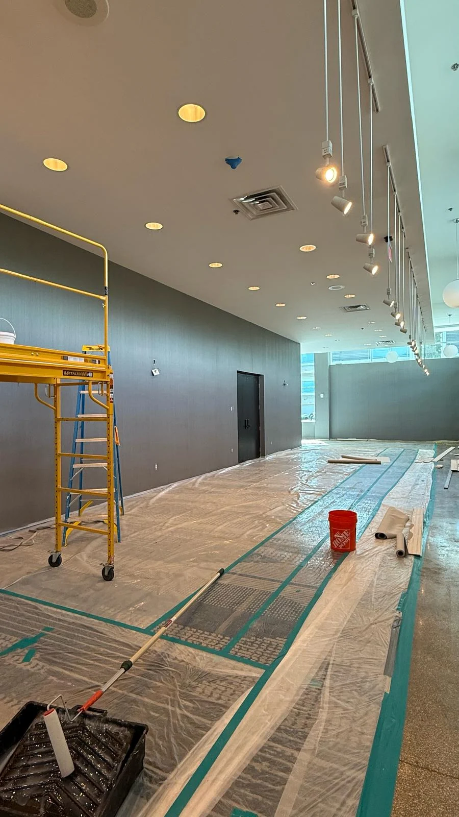 Hallway wallcovering installation area with scaffold, materials and existing carpet protected · Hotel Alba Tampa, Tapestry Collection by Hilton