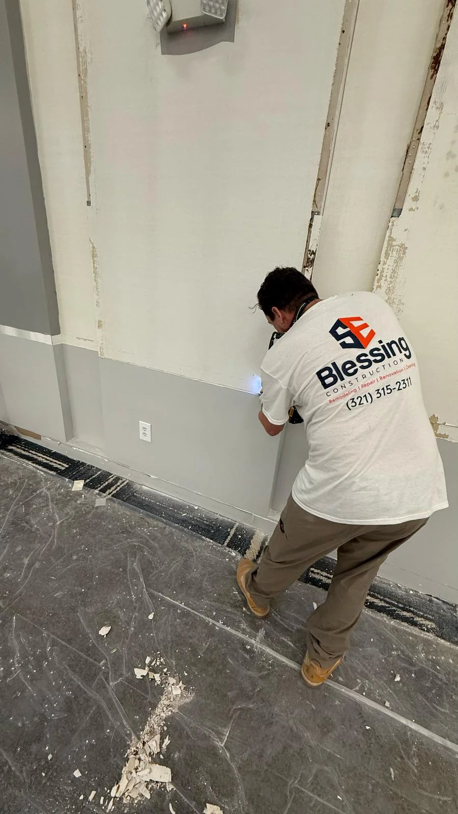 SE Blessing crew member removing material from the wall · Tapestry Collection by Hilton
