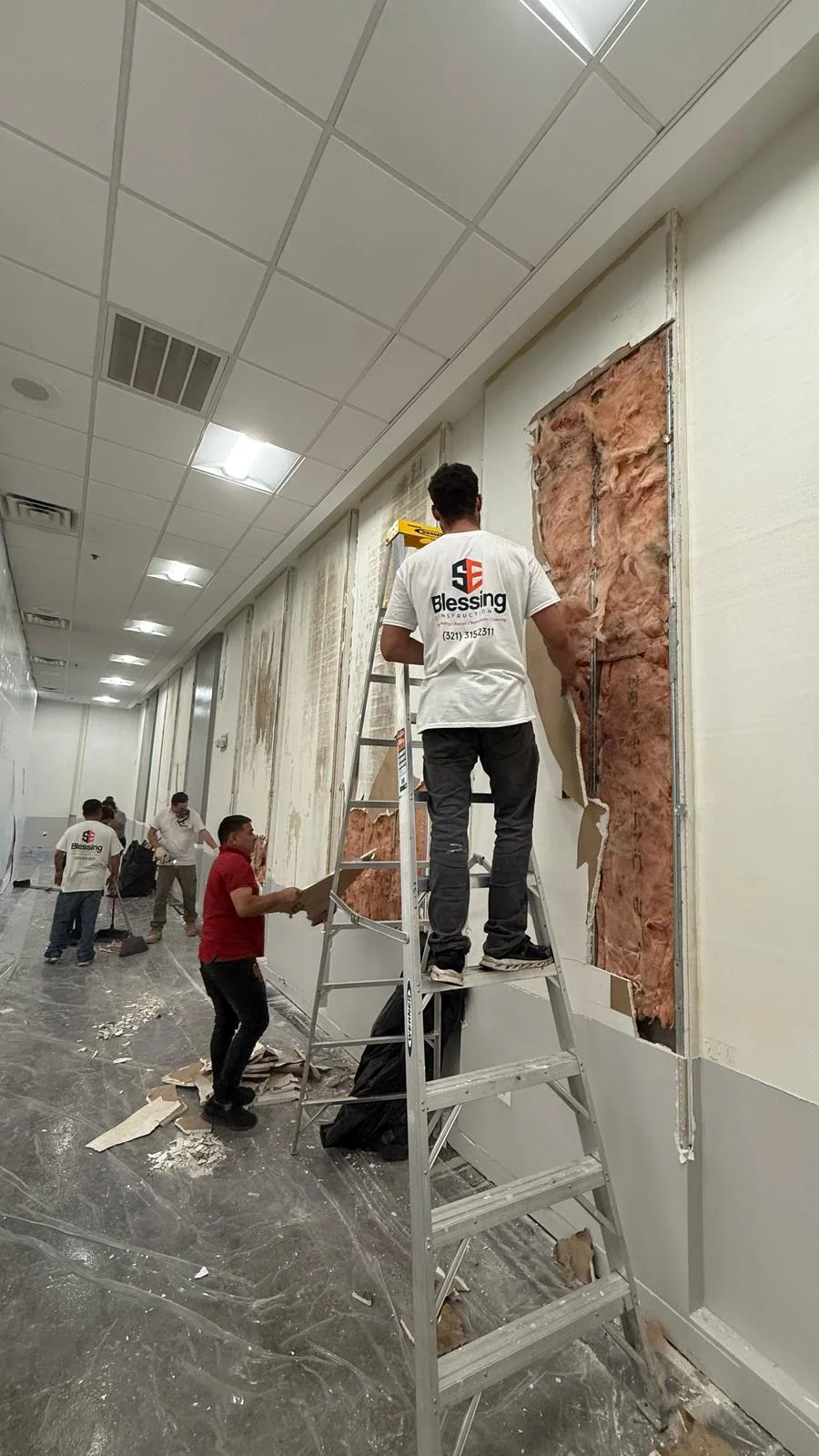 Crew removing wall material to expose the insulation and framing · Tapestry Collection by Hilton