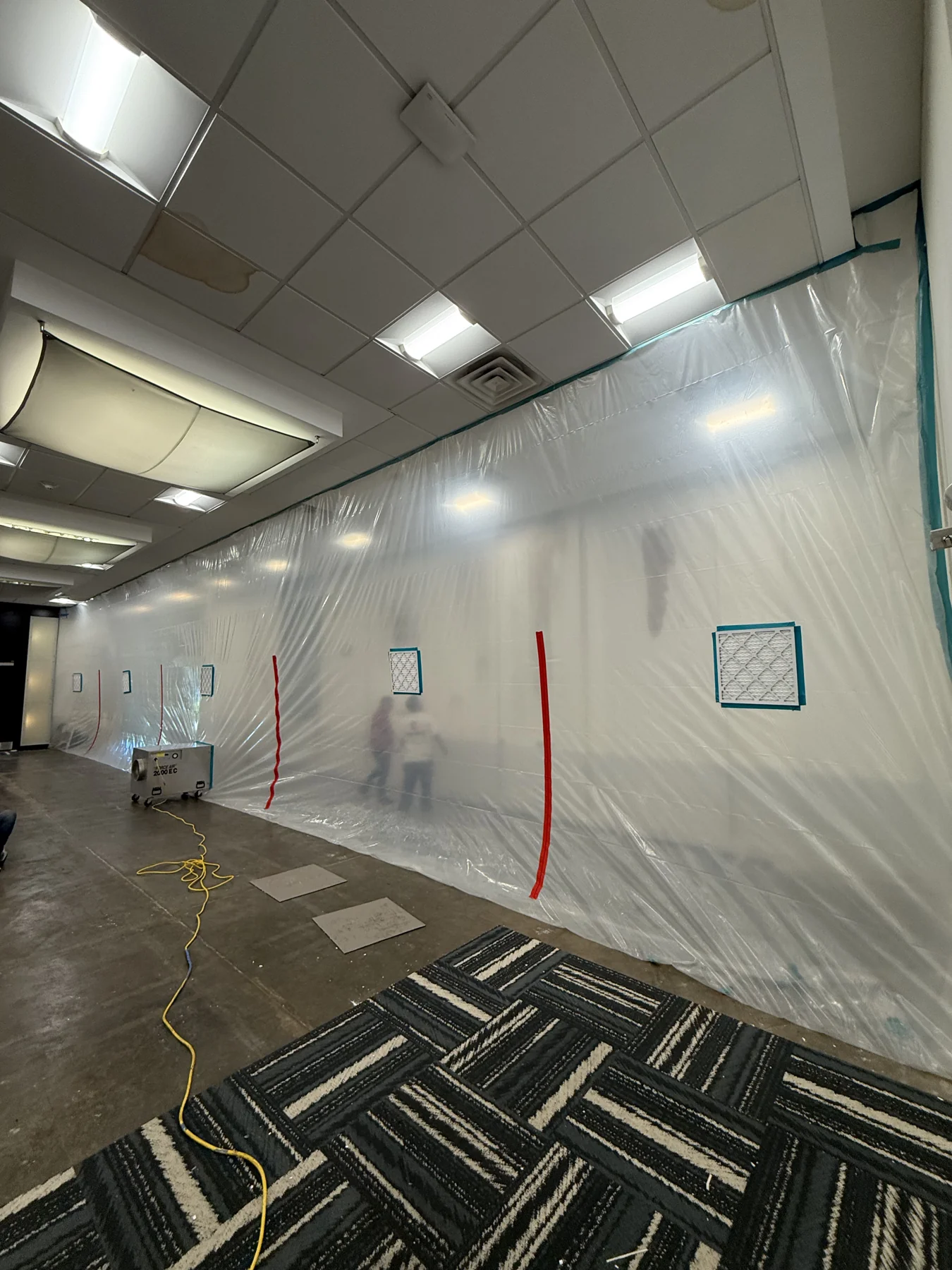 Plastic containment sheeting separating the wall work from the rest of the room · Tapestry Collection by Hilton