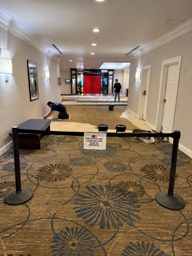 Crew preparing the exposed floor beside the remaining carpet at DoubleTree by Hilton, Jacksonville