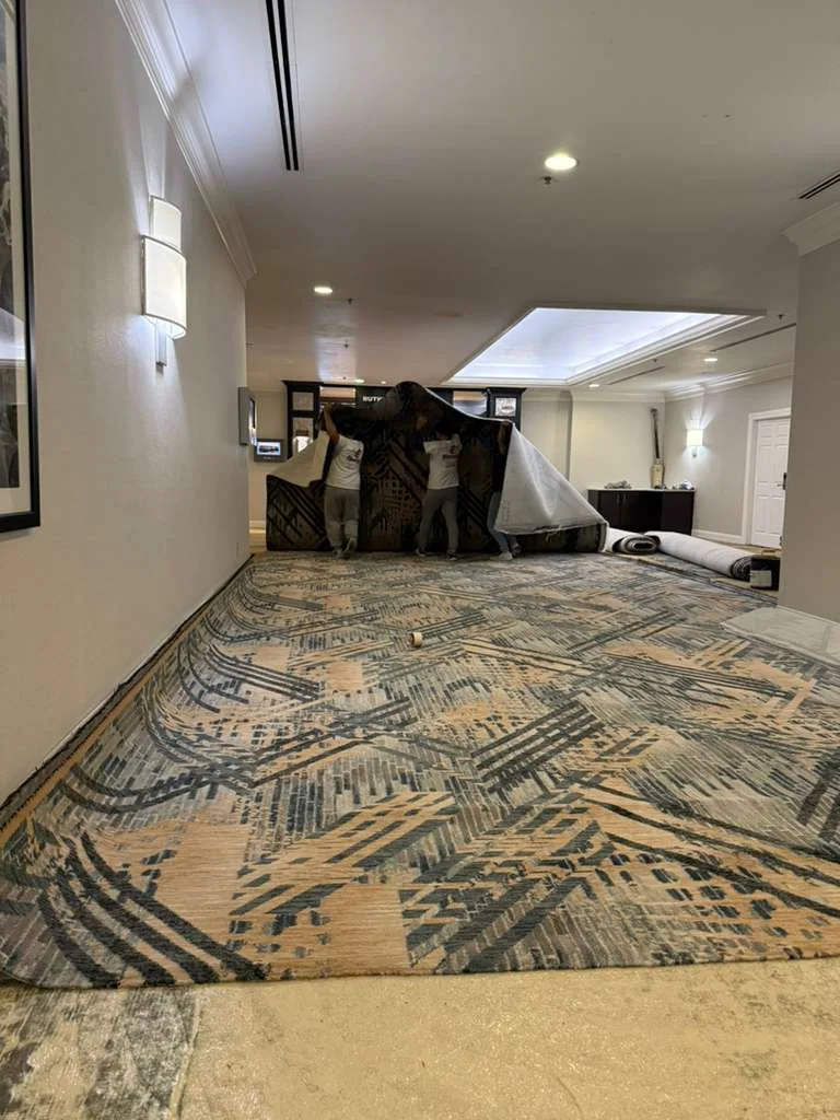 Crew positioning new carpet across the corridor at DoubleTree by Hilton, Jacksonville
