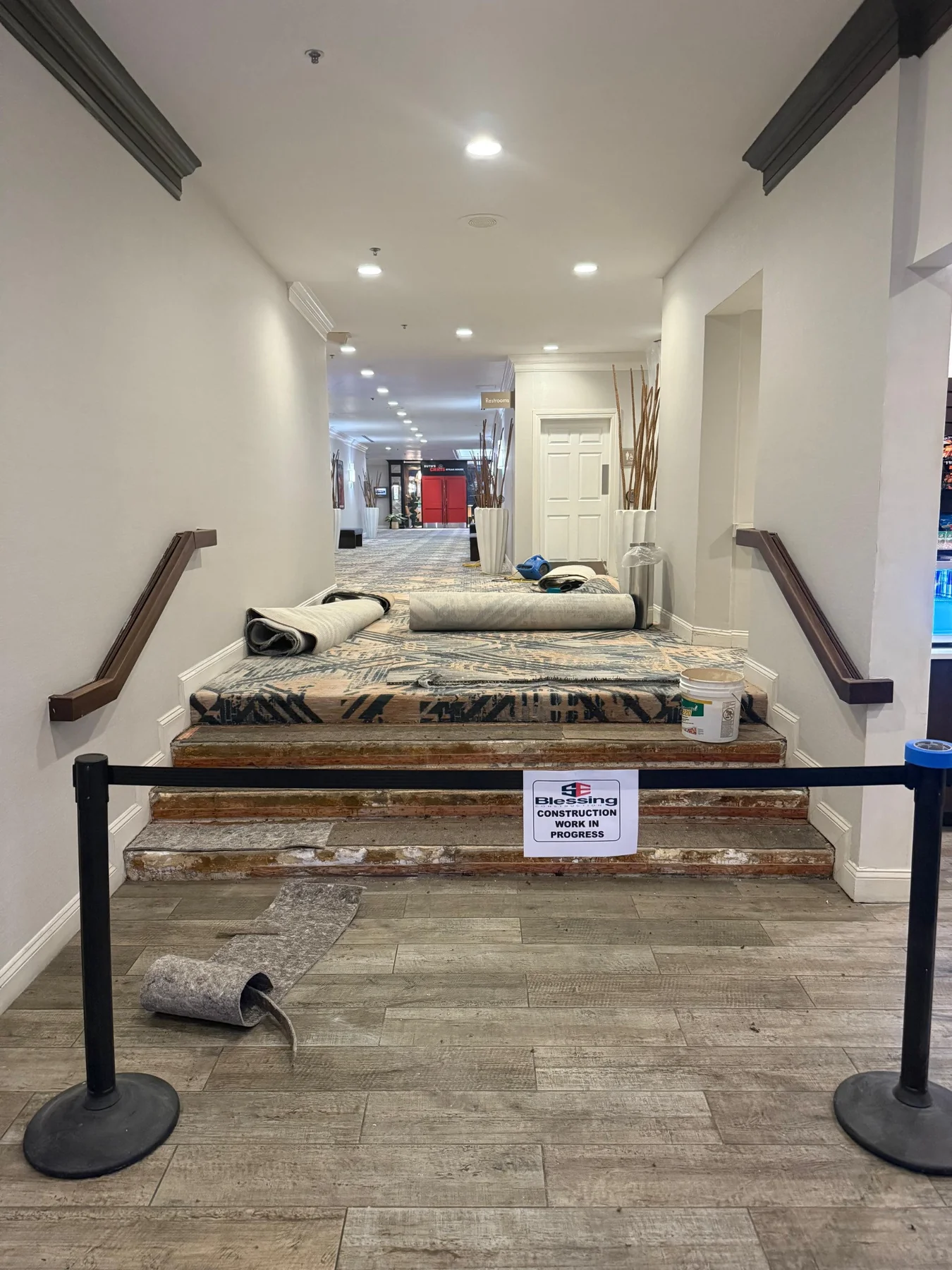 Carpet installation at the hallway steps with exposed treads, carpet rolls and a work-in-progress barrier at DoubleTree by Hilton, Jacksonville