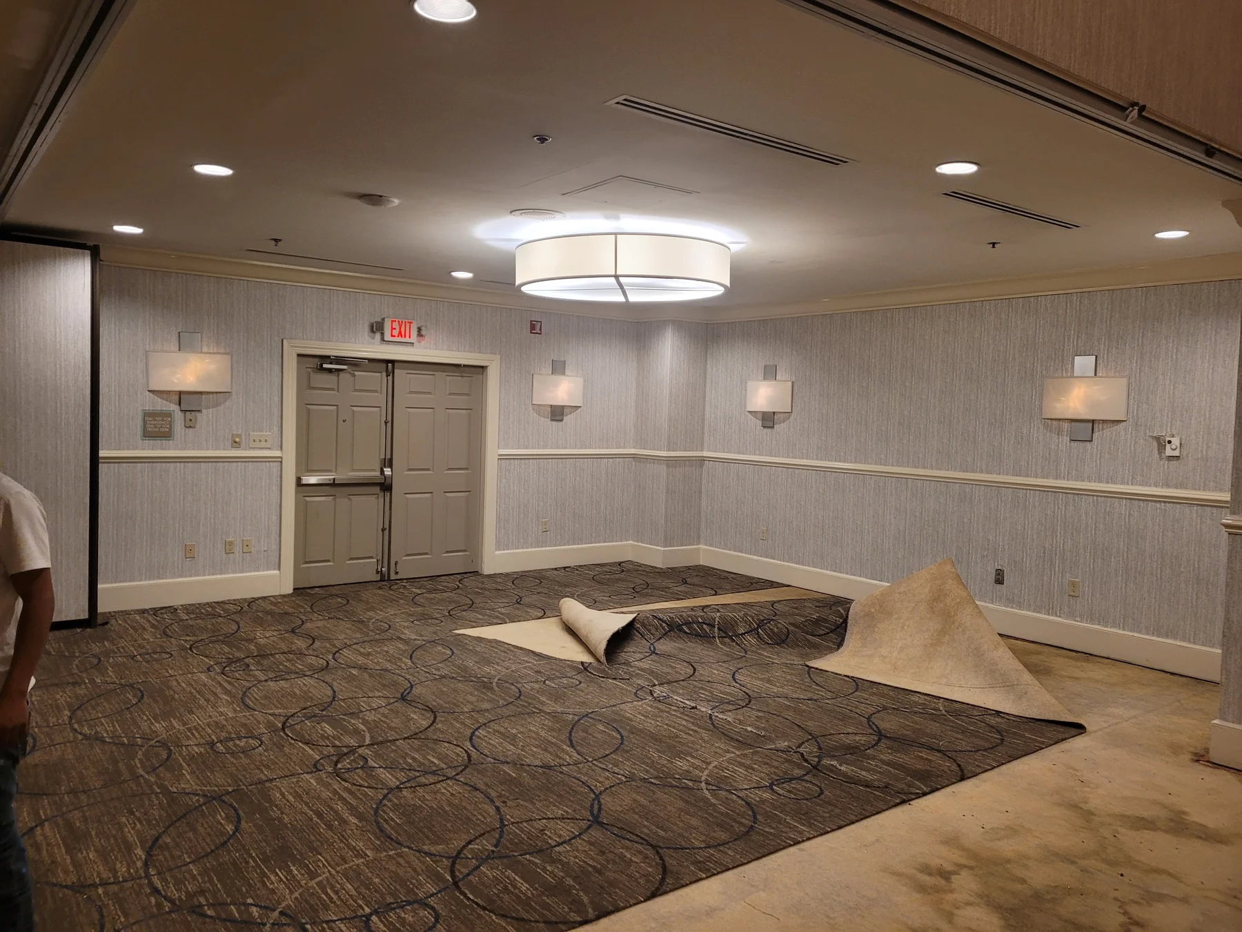 Existing brown carpet being lifted and removed from a DoubleTree by Hilton ballroom section
